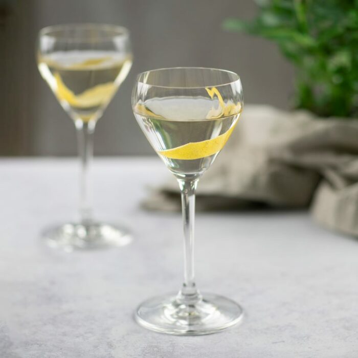 To drink glass med klart innhold og en liten bit skal fra sitron